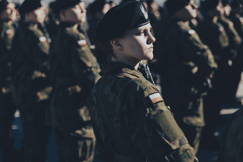 żołnierz w mudnurze z bronią na ramieniu