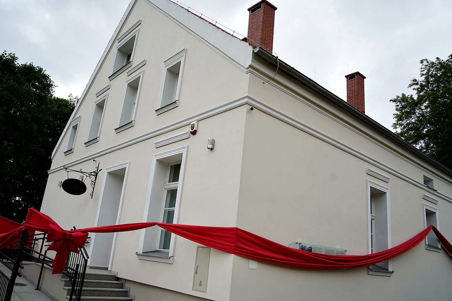 Dom nz Wzgórzu po remoncie opasany czerwoną kokardą kokardą