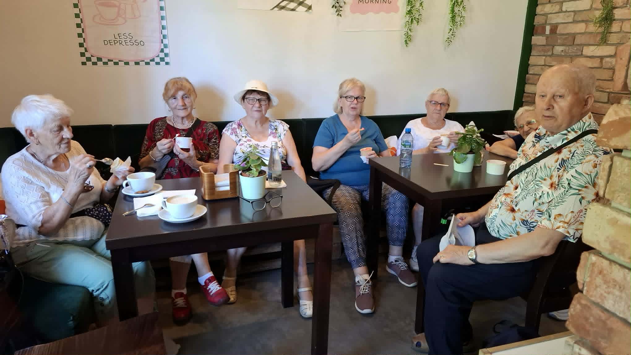 Seniorzy siedzący przy stoliku